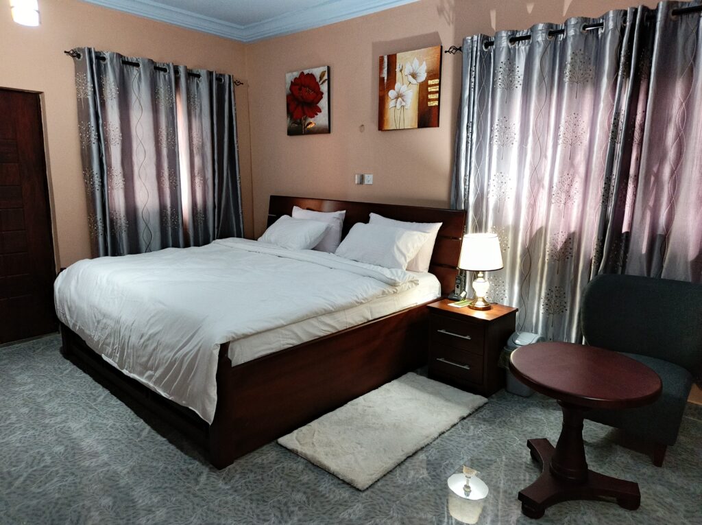 Executive Grand Suite with 180-degree city view balcony and two sofas at Green Apple Hotel East Legon.