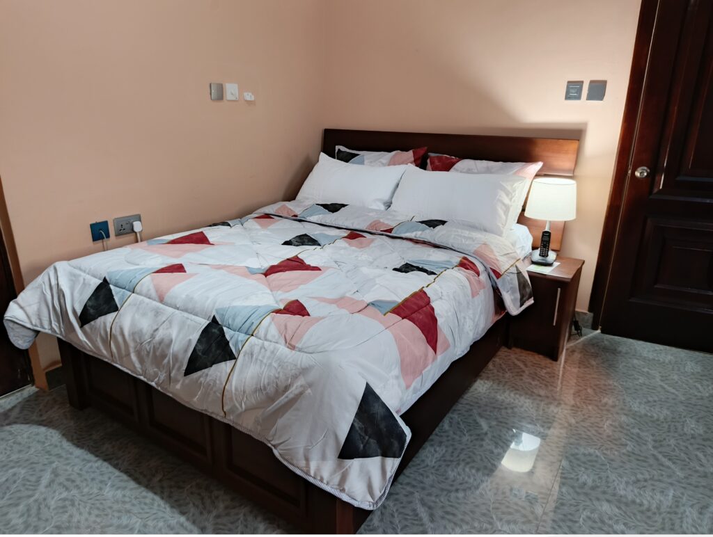 Spacious Standard hotel room in East Legon Hills with King-size bed and work desk at Green Apple Hotel.