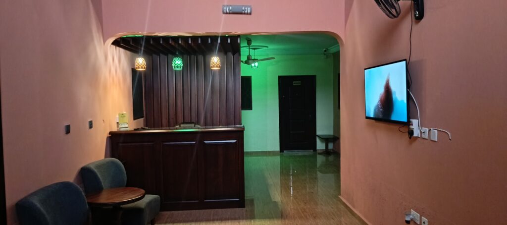 A spacious hotel room desk setup with a laptop, showcasing the business-ready amenities and reliable power at Green Apple Hotel.